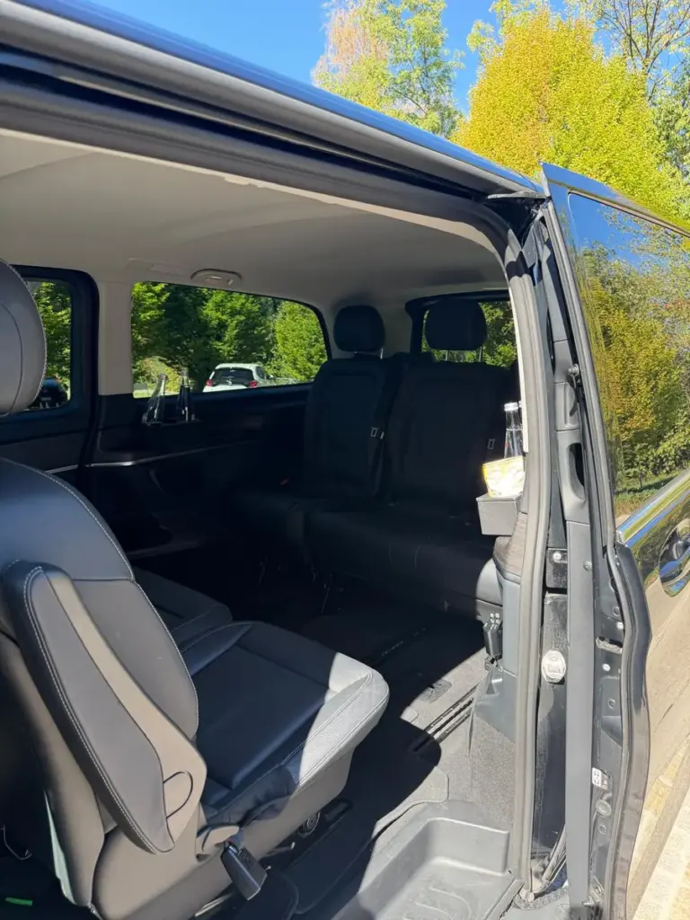 Fahrgastraum der Mercedes V-Klasse mit schwarzen Sitzen, durch die geöffnete Schiebetür gesehen